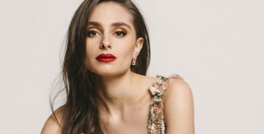 Esther Abrami in a pink and green dress looking straight into the camera